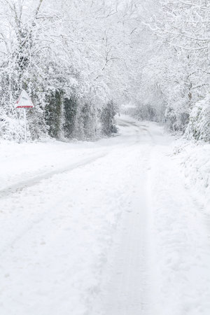 British country lane in rural countryside covered in snow in winter. Buckinghamshire, UKの写真素材