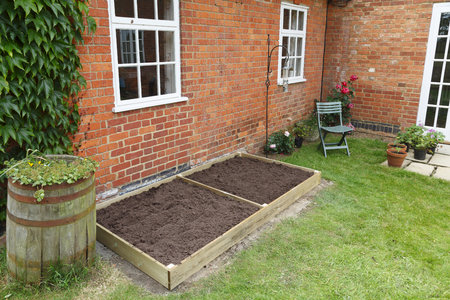 A new empty raised bed in a kitchen garden is filled with soil ready to plantの写真素材