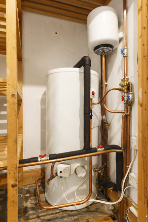 Unvented hot water cylinder and expansion vessel in an airing cupboard. UK plumbingの写真素材