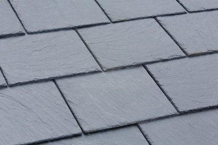 Closeup of traditional grey slate roof tiles on a pitched roofの写真素材