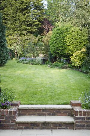 Terraced back garden with lawn, steps and patio in England, UKの写真素材