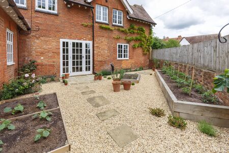 House and garden with a terrace patio and french doors, gravel hard landscaping and york stone pathの写真素材