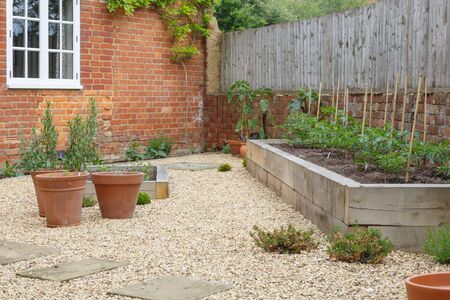 Garden with terracotta plant pots, oak sleeper raised beds and gravelの写真素材