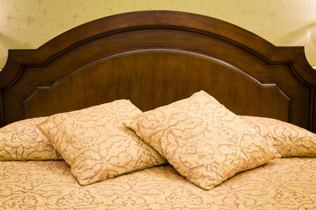 Bedroom interior of a traditional bed with headboard, pillows and cushionsの写真素材