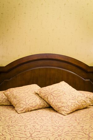 Bed with bed linen against a bedroom wall, ideal for copyspaceの写真素材