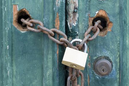 Padlock and chain on an old door, illustrating concepts of security and encryption