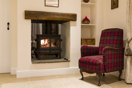Cosy woodburner and chair in an English home, UKの写真素材