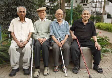 BENGALURU, INDIA - June 25, 2010. Group of old Indian senior men relax on a park bench in Bangalore, Indiaのeditorial素材
