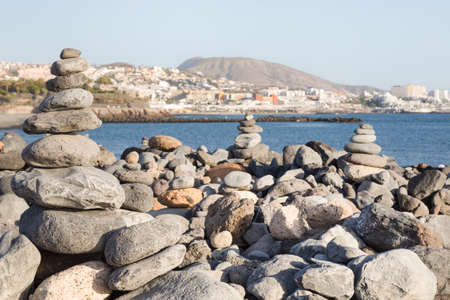 Piles of stones balanced, stacked in a pyramid on a beach in Costa Adeje, Tenerife, Canary Islandsの写真素材