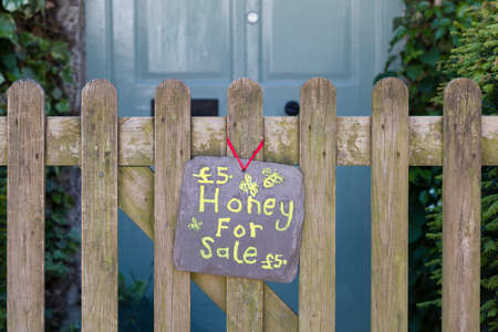 BUCKINGHAM, UK - May 25, 2020. Honey for sale sign outside a house. Home business selling fresh produce, UKのeditorial素材