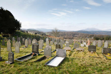 CONWY, WALES - March 02, 2012. Graves in a graveyard or cemetery in Snowdonia landscape. Capel...