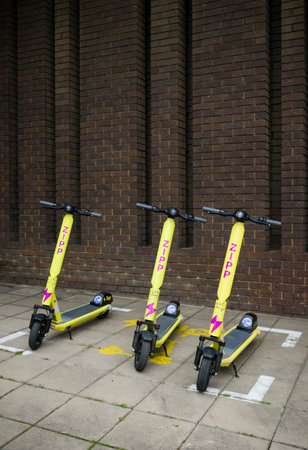 AYLESBURY, UK - July 01, 2021. Rental e-scooters parked on a pavement in a UK town. Electric scooter or kick scooter.のeditorial素材
