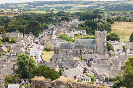 DORSET, UK - July 06, 2022. Saint Edward parish church in Corfe Castle village. Aerial view of pretty rural town in Purbeck, Dorsetのeditorial素材