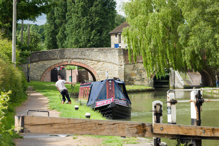 NORTHAMPTONSHIRE, UK - May 25, 2022. Man mooring narrowboat on a canal at Stoke Bruerne, a historic village on the Grand Union Canalのeditorial素材
