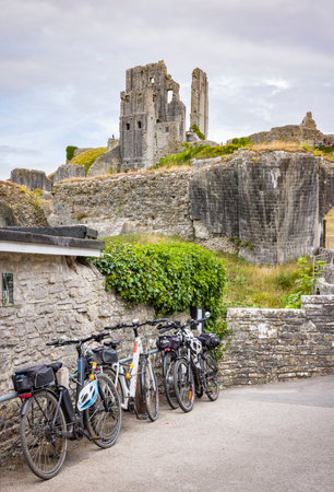 DORSET, UK - July 06, 2022. Touring bikes parked outside Corfe Castle ruins, Dorset, UK. Depicts exploring England on a cycle tourのeditorial素材
