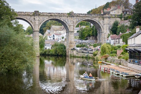 KNARESBOROUGH, UK - September 20, 2022. Tourists hire a rowing boat on the River Nidd below Knaresborough Railway Viaduct, Knaresborough, North Yorkshire, UKのeditorial素材