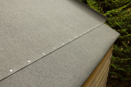 Replacing felt on a shed roof. Part of a series showing a roof being replaced on a shed in a UK...