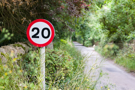 20mph speed limit sign on a narrow country road. 20 mph speed restriction in Oxfordshire, UKの写真素材