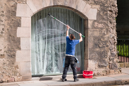 EDINBURGH, UK - May 30, 2024. Window cleaner cleaning a window of a historic building in Edinburgh, Scotland, UKのeditorial素材