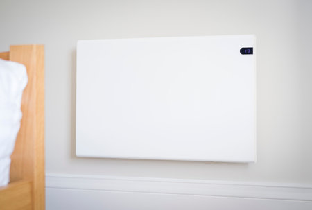 Modern electric heating panel radiator on a bedroom wall, home interior, UKの写真素材