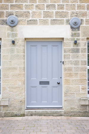 Grey painted wood front door to an apartment in a converted ancient mill house. Nidderdale, Yorkshire Dales, UKの写真素材