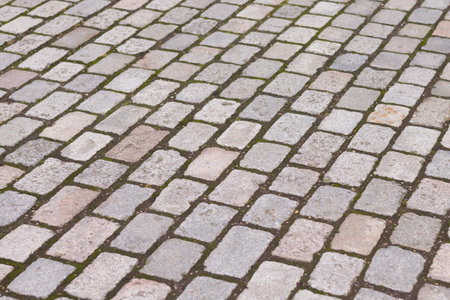 Vintage grey tumbled paving blocks in a UK street. Full frame background, texture or patternの写真素材