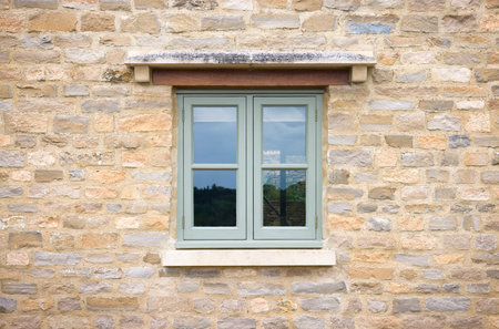Green painted wooden window on a Cotswold stone cottage, UKの写真素材