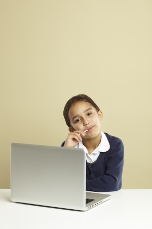 Young girl using laptop on white deskの写真素材