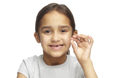 Young girl with missing front tooth on white backgroundの写真素材
