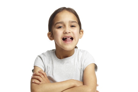 Young girl with missing front tooth on white backgroundの写真素材