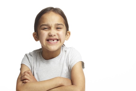Young girl with missing front tooth on white backgroundの写真素材