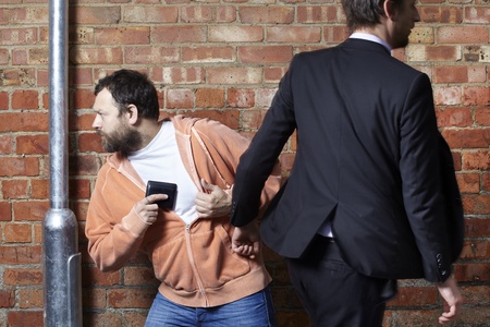 Man has his wallet pickpocketed whilst walking along the streetの写真素材