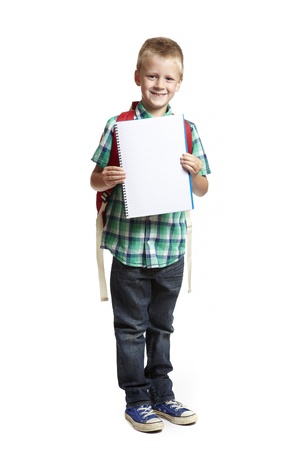 8 year old school boy with backpack holding blank notepad on white backgroundの写真素材