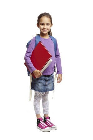 8 year old school girl with backpack holding books smiling on white backgroundの写真素材