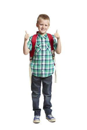 8 year old school boy with thumbs up and backpack on white backgroundの写真素材