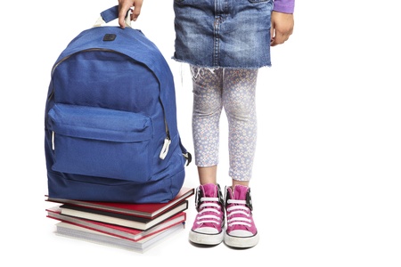8 year old school girl with books and backpack on white backgroundの写真素材