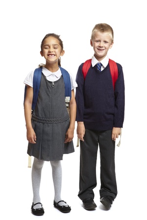 8 year old school boy and girl with backpacks smiling on white backgroundの写真素材