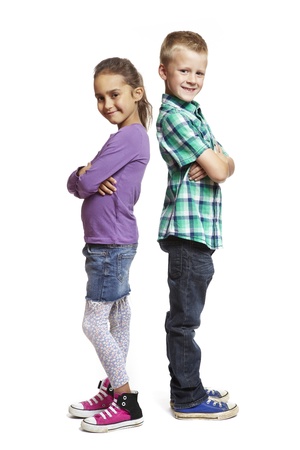 8 year old boy and girl stood back to back on white backgroundの写真素材