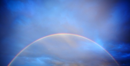 Rainbow infront of stormy sunset skyの写真素材