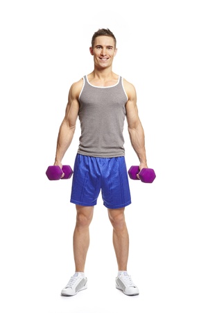 Muscular young man exercising in sports outfit holding dumbbells smiling on white backgroundの写真素材