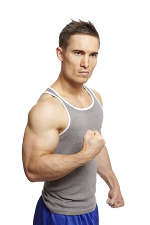 Muscular young man flexing arm muscles in sports outfit on white backgroundの写真素材