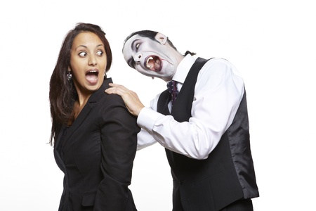 Man in dracula fancy dress costume biting girls neck on white backgroundの写真素材