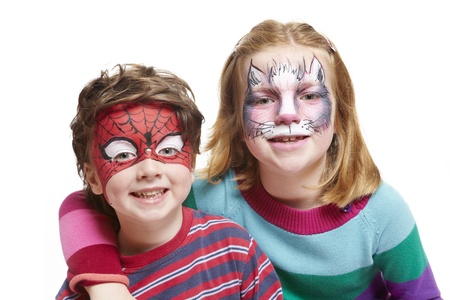 Young boy and girl with face painting of cat and spiderman smiling on white backgroundの写真素材