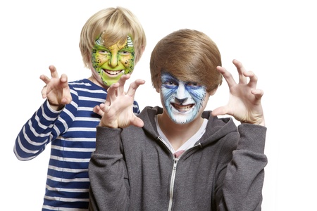 Teenage and young boys with face painting monster and wolf growling on white backgroundの写真素材