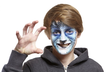 Teenage boy with face painting wolf growling on white backgroundの写真素材