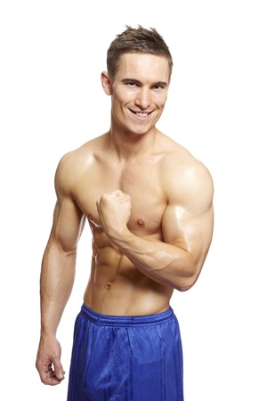 Muscular young man flexing arm muscles in sports outfit smiling on white backgroundの写真素材