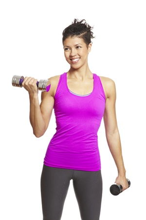 Young woman exercising in sports outfit holding dumbbells on white backgroundの写真素材