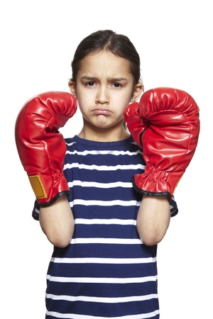 Young girl wearing boxing gloves sad and upset on white backgroundの写真素材
