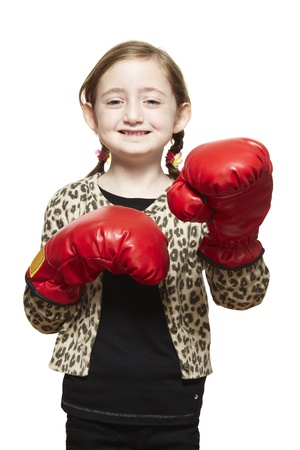 Young girl wearing boxing gloves smiling on white backgroundの写真素材