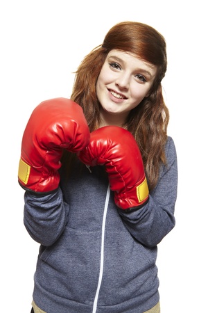 Young teenage girl wearing boxing gloves smiling on white backgroundの写真素材